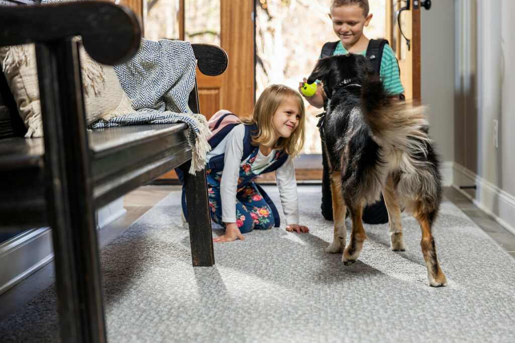Kids plying with dog on carpet flooring | A & S Carpet Collection